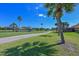 Lush backyard with a walking path, water views, and mature palm trees providing a tropical setting at 10411 Winding Stream Way, Bradenton, FL 34212