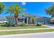 Charming home features a well-manicured lawn, lush landscaping, and a stately palm tree, all enhancing its curb appeal at 10411 Winding Stream Way, Bradenton, FL 34212