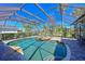Screened-in pool area with rock waterfall feature, surrounded by palm trees at 10411 Winding Stream Way, Bradenton, FL 34212