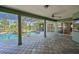 Covered pool area with a rock waterfall, landscaping, and tile flooring at 10411 Winding Stream Way, Bradenton, FL 34212
