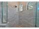 Shower with glass doors, pebbled floor, rain shower head, and decorative, arched windows at 10411 Winding Stream Way, Bradenton, FL 34212