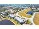 Aerial view showcasing waterfront condos within a well-maintained community with lush landscaping at 10720 Lemon Creek Loop # 103, Englewood, FL 34224