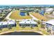Aerial view of waterfront condos nestled within a community with mature landscaping and ponds at 10720 Lemon Creek Loop # 103, Englewood, FL 34224