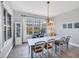 Bright dining room with large windows, chandelier lighting, and seating for eight at 10720 Lemon Creek Loop # 103, Englewood, FL 34224