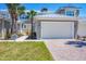 Charming townhome exterior with two-car garage, brick driveway, and lush lawn at 10720 Lemon Creek Loop # 103, Englewood, FL 34224