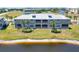 Rear exterior view of a waterfront condo with a metal roof, screened lanais, and manicured landscaping at 10720 Lemon Creek Loop # 103, Englewood, FL 34224