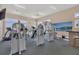 Well-equipped gym with multiple exercise machines, ceiling fans, and a wall-mounted TV at 10720 Lemon Creek Loop # 103, Englewood, FL 34224