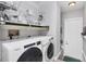 Functional laundry room equipped with modern washer and dryer units, shelving, and ample storage space at 10720 Lemon Creek Loop # 103, Englewood, FL 34224