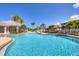 Resort-style community pool surrounded by tropical landscaping and comfortable lounge chairs at 10720 Lemon Creek Loop # 103, Englewood, FL 34224