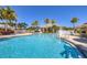 Inviting community pool with clear blue water and lush landscaping on a sunny day at 10720 Lemon Creek Loop # 103, Englewood, FL 34224