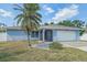 Charming single Gathering home with a well-manicured lawn, a palm tree, and an attached two-car garage at 108 Stanford Rd, Venice, FL 34293