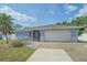Charming single-story home featuring an attached two-car garage, well-maintained lawn, and mature palm tree at 108 Stanford Rd, Venice, FL 34293
