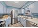 Bright kitchen features stainless steel appliances, a blue backsplash, and wood-look flooring at 108 Stanford Rd, Venice, FL 34293