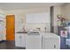 Bright laundry room with modern washer, dryer, sink, white cabinetry, and access door at 108 Stanford Rd, Venice, FL 34293