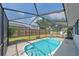 Charming fenced-in pool area with comfortable lounge chairs under a screened enclosure at 108 Stanford Rd, Venice, FL 34293