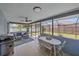Inviting screened patio featuring a grill, seating area, and an adjacent dining table at 108 Stanford Rd, Venice, FL 34293