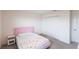 Cozy bedroom features a pink bedframe, plush carpeting, closet, and modern bedside table at 11510 Sweetgrass Dr, Bradenton, FL 34212