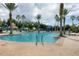 Community pool featuring ladder access, lush landscaping, and surrounding lounge chairs at 11702 Anhinga Avenue, Venice, FL 34292