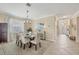 Dining area with glass-top table, six chairs, chandelier and access to the front entryway at 11702 Anhinga Avenue, Venice, FL 34292