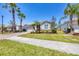 Inviting home with a brick driveway, lush landscaping, and palm trees in a tranquil neighborhood at 11702 Anhinga Avenue, Venice, FL 34292