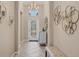 Elegant foyer featuring tile flooring, chandelier, decorative wall art, and a front entry door at 11702 Anhinga Avenue, Venice, FL 34292