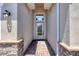Covered front entry with stone accents, decorative glass door, and brick pathway at 11702 Anhinga Avenue, Venice, FL 34292