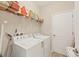 This laundry room is equipped with a washer, dryer, and storage shelves at 11702 Anhinga Avenue, Venice, FL 34292