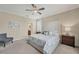 This main bedroom features a plush, upholstered headboard, ceiling fan, and ensuite bathroom at 11702 Anhinga Avenue, Venice, FL 34292