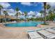 Large community pool surrounded by palm trees and lounge chairs, with a clubhouse in the background at 11702 Anhinga Avenue, Venice, FL 34292