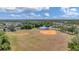 A view of a recreation field, pond, and tennis courts from high above the ground at 11702 Anhinga Avenue, Venice, FL 34292