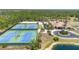Aerial view of community tennis courts, clubhouse, and pond at 11702 Anhinga Avenue, Venice, FL 34292