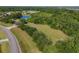 An aerial view features a soccer field near a road and wooded area at 14265 17Th E Ct, Parrish, FL 34219