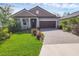 Attractive single-story home with lush green lawn, brick driveway, and well-maintained landscaping at 14265 17Th E Ct, Parrish, FL 34219