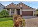 Charming single-story home featuring a well-manicured lawn, brick driveway, and two-car garage at 14265 17Th E Ct, Parrish, FL 34219
