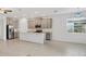 Modern kitchen with stainless steel appliances, gray cabinets, island with sink, and tile flooring at 14265 17Th E Ct, Parrish, FL 34219