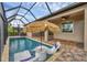 An inviting pool with lounge chairs and a sun umbrella extends to the outdoor patio area, offering a relaxing space at 14265 17Th E Ct, Parrish, FL 34219