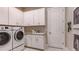 Well-organized laundry room featuring modern washer, dryer, and ample cabinet space at 14907 Contenta Loop, Bradenton, FL 34211