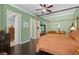 Spacious bedroom featuring a canopy bed, hardwood floors, green walls, and three doors at 1520 Dorgali Dr, Sarasota, FL 34238