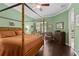 Bedroom featuring a canopy bed, hardwood floors, a ceiling fan, a desk, and a sliding glass door at 1520 Dorgali Dr, Sarasota, FL 34238