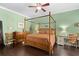 Spacious bedroom with a canopy bed, ceiling fan, hardwood floors, and light green walls at 1520 Dorgali Dr, Sarasota, FL 34238