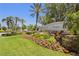 Well-maintained community entrance sign with vibrant landscaping and mature palm trees at 1520 Dorgali Dr, Sarasota, FL 34238