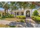 Charming home featuring a welcoming front porch, arched entryway, and beautifully landscaped front yard at 1520 Dorgali Dr, Sarasota, FL 34238