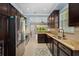 Galley kitchen with stainless steel appliances, granite countertops, and dark cabinets, plus window and view at 1520 Dorgali Dr, Sarasota, FL 34238