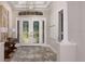 Elegant foyer features double glass doors, tray ceiling, and stylish decor, setting a sophisticated tone at 15408 San Lazzaro Ave, Bradenton, FL 34211