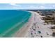 Expansive aerial shot of the beach with clear turquoise water and beachfront condos in the distance at 1724 Cheyenne St, Sarasota, FL 34231