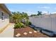 Landscaped backyard featuring a well-maintained fence, mulched garden beds, stone pavers, and healthy plants at 1724 Cheyenne St, Sarasota, FL 34231