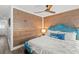 Charming bedroom features a wood accent wall, ceiling fan, and light-colored wood-look flooring at 1724 Cheyenne St, Sarasota, FL 34231