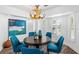 Dining room featuring an antler chandelier, blue upholstered chairs, and large windows with shutters at 1724 Cheyenne St, Sarasota, FL 34231
