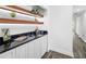 Hallway featuring a bar with granite countertop, wood-look floors and white cabinets at 1724 Cheyenne St, Sarasota, FL 34231