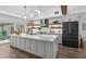 Modern kitchen featuring a large island, sleek cabinetry, stylish pendant lighting, and stainless steel appliances at 1724 Cheyenne St, Sarasota, FL 34231